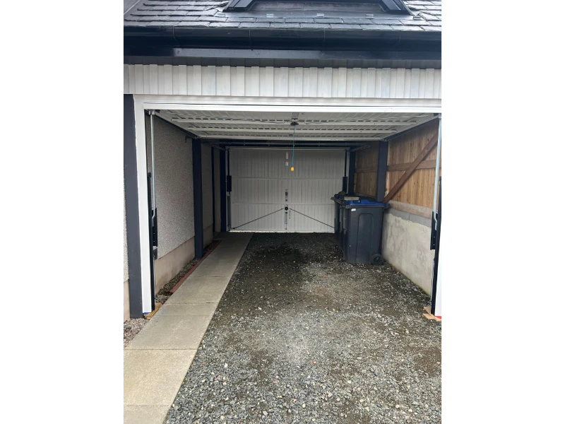 Commercial carport bay with garage door closed and tracks visible — commercial door & dock services in Alvin, TX.