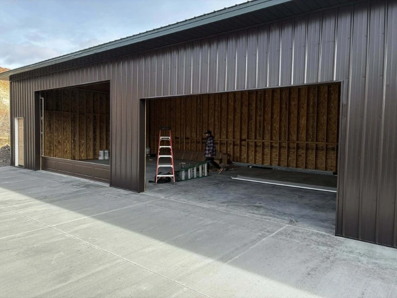 Metal building with large openings used as commercial overhead door repair bays.