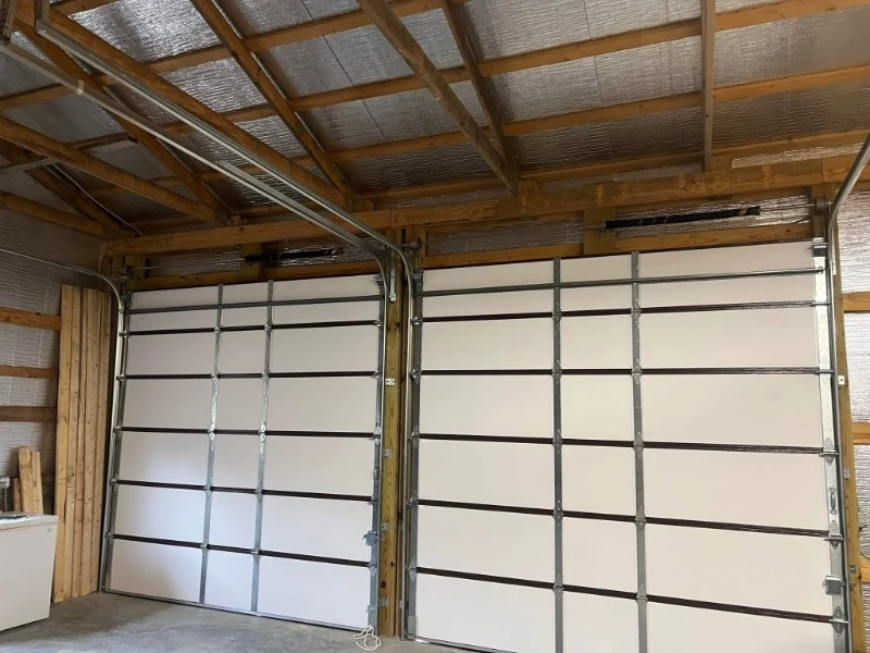 Two sectional overhead doors installed inside a workshop or warehouse building.