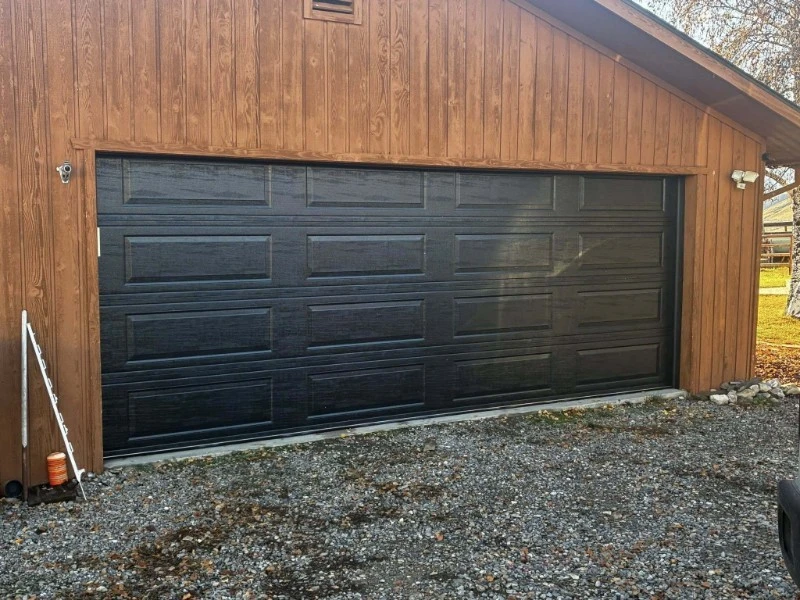 Emergency Garage Door Repair in Alvin, TX – black raised-panel garage door on wood garage