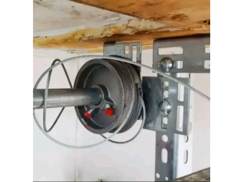 Garage Door Cable, Drum & Bottom Bracket Repair in Alvin, TX – Rolling steel / garage door drum and bottom bracket alignment check during repair
