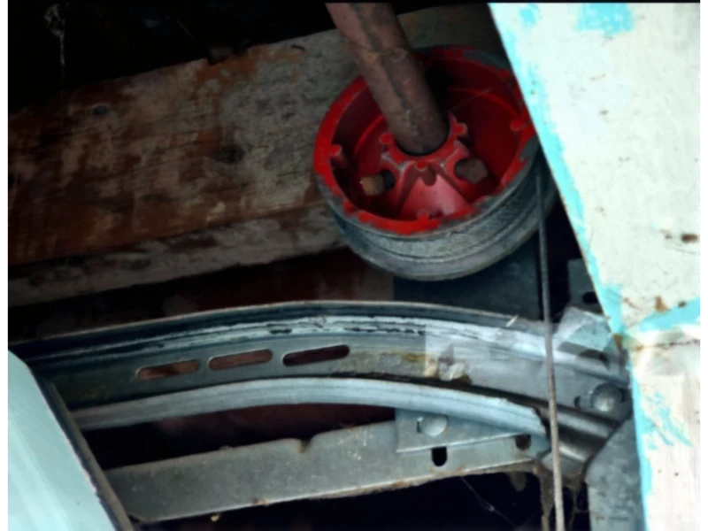 Garage Door Cable, Drum & Bottom Bracket Repair in Alvin, TX – Close-up of garage door cable drum and lift cable winding on the torsion shaft
