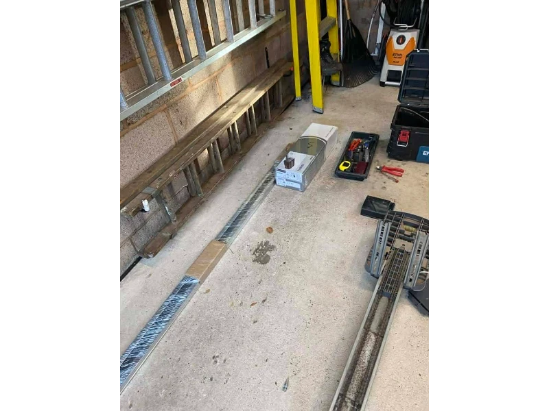 Tools and parts laid out for garage door cable, drum, and bottom bracket repair in Alvin, TX.