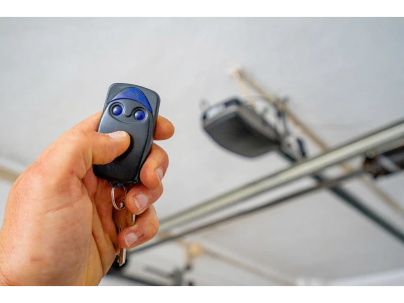 Garage Door Keypad & Remote Programming Alvin, TX – close-up of remote with garage door opener in the background.