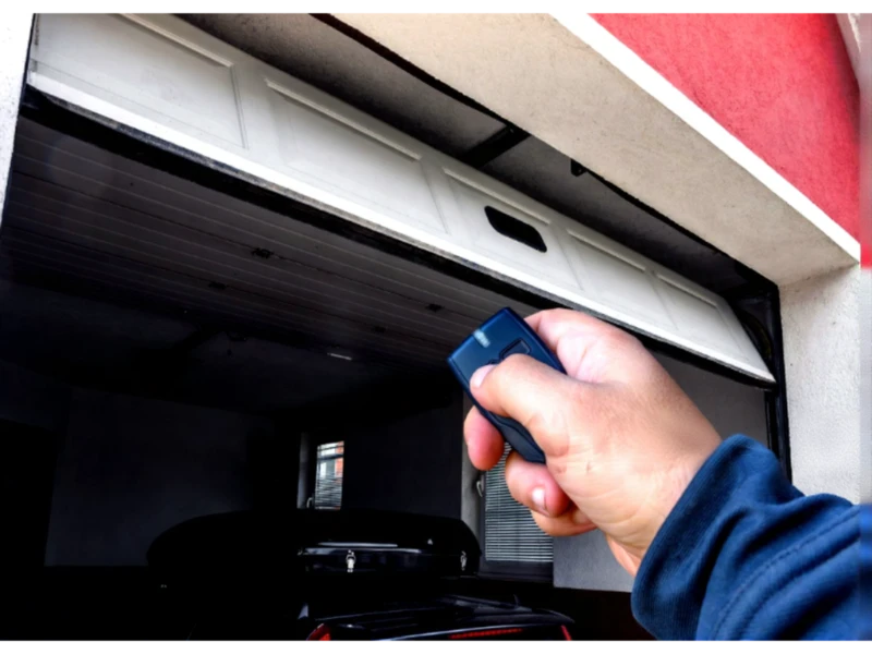 Garage Door Keypad & Remote Programming Alvin, TX – remote opening the garage door from the driveway (angled view).