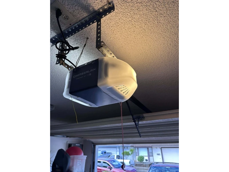 Chamberlain garage door opener mounted to the ceiling during opener installation in Alvin, TX.