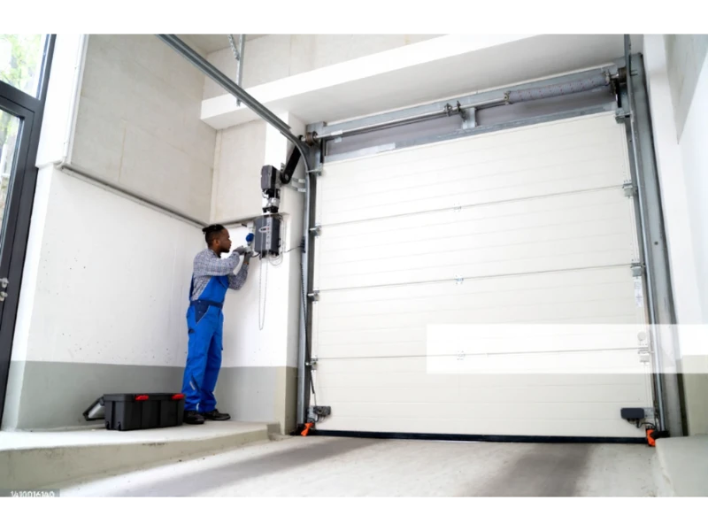 Garage Door Opener Installation in Alvin, TX - technician working on wall-mounted operator control box

