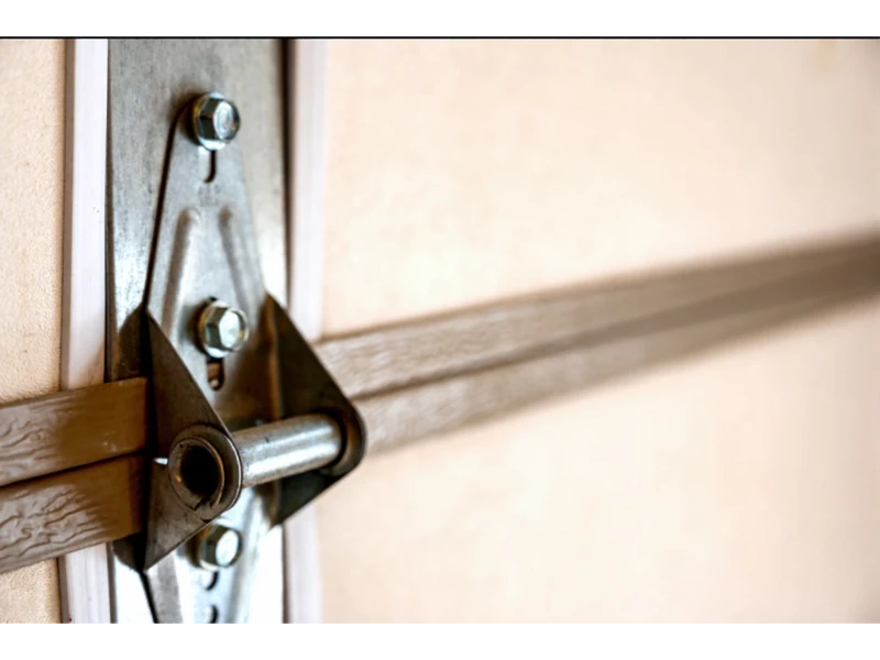 Close-up of a garage door hinge and roller bracket for track alignment in Alvin, TX.