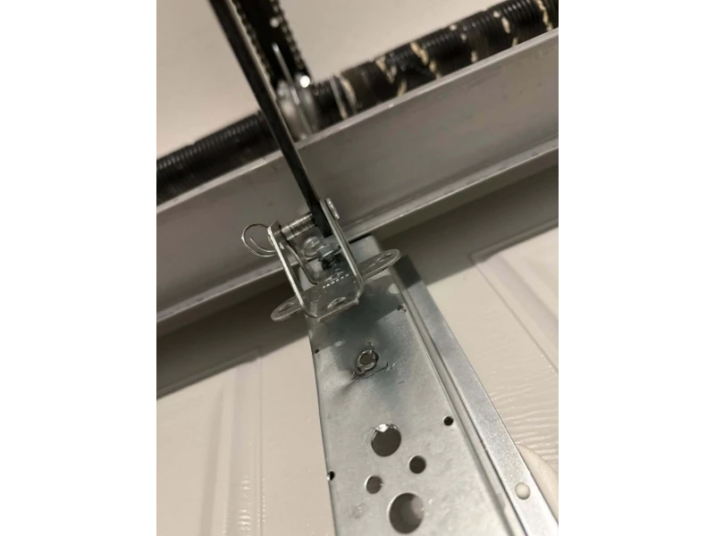 Garage door track bracket hardware repair to secure the vertical track in Alvin, TX.