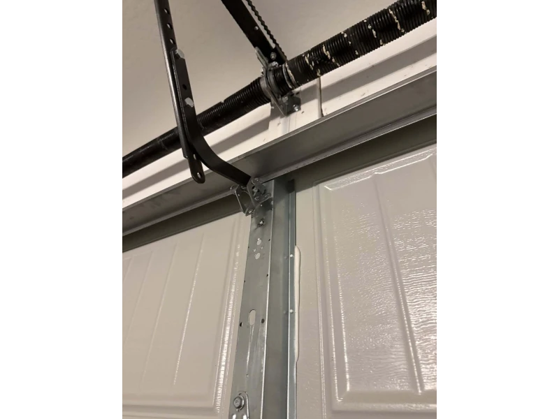 Reinforced garage door track bracket to prevent movement and improve roller tracking in Alvin, TX.