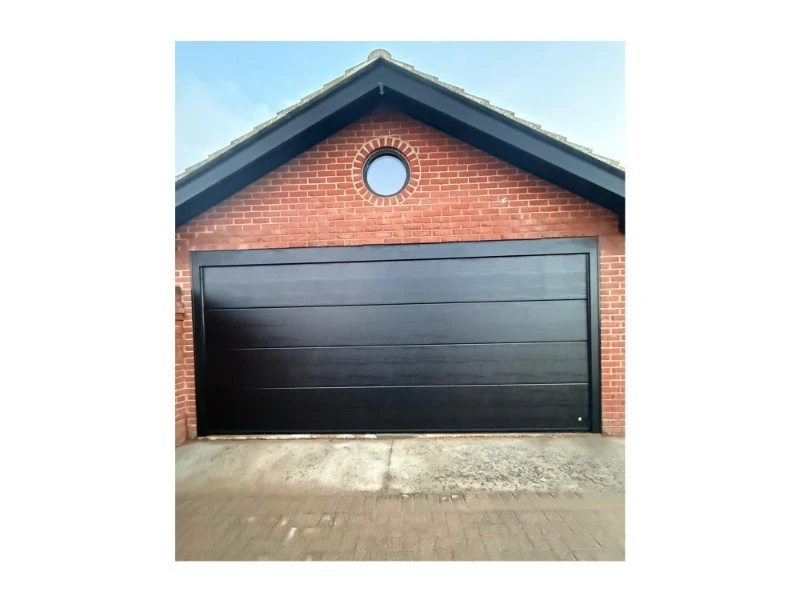 Black sectional garage door on a brick home—installation and repair services in Alvin, TX.
