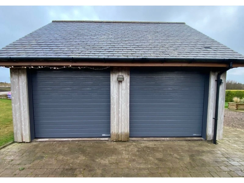 Exterior view of double garage doors—maintenance and repair services available in Alvin, TX.
