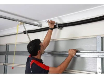 Technician repairing a torsion spring for safe, dependable garage door service in Alvin, TX.