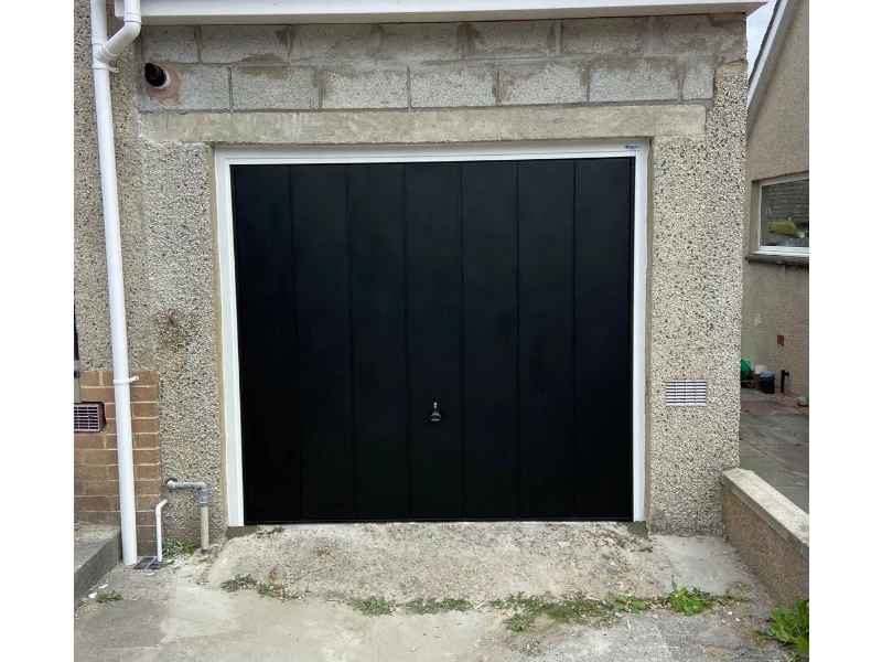 Black garage door installed within a white frame opening for a sharp contrast (Alvin, TX).