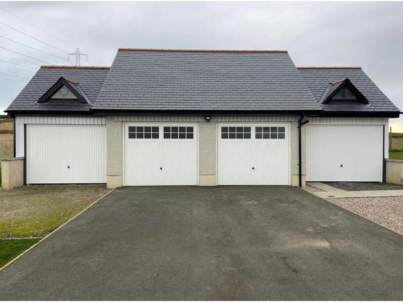 New multi-bay white garage doors installed on a detached garage (Alvin, TX installation & replacement).