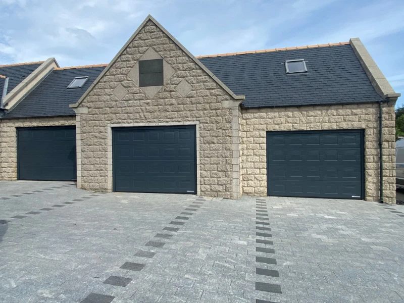 Three-car garage door installation on a stone home with matching dark doors (Alvin, TX).